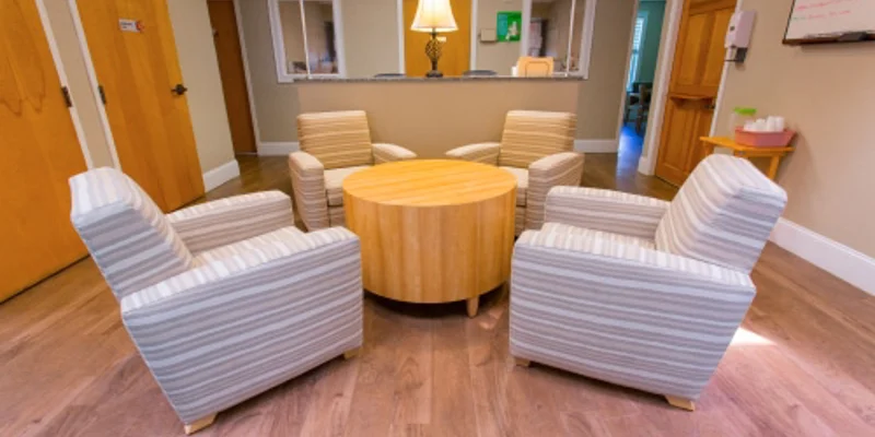 A small seating area with four striped armchairs and a round table.