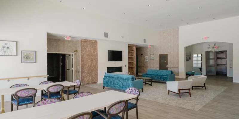 Open common area with dining tables, couches, and a TV.
