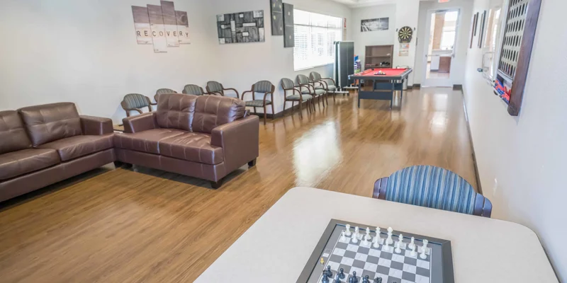Lounge with couches leading into recreational area with a pool table.