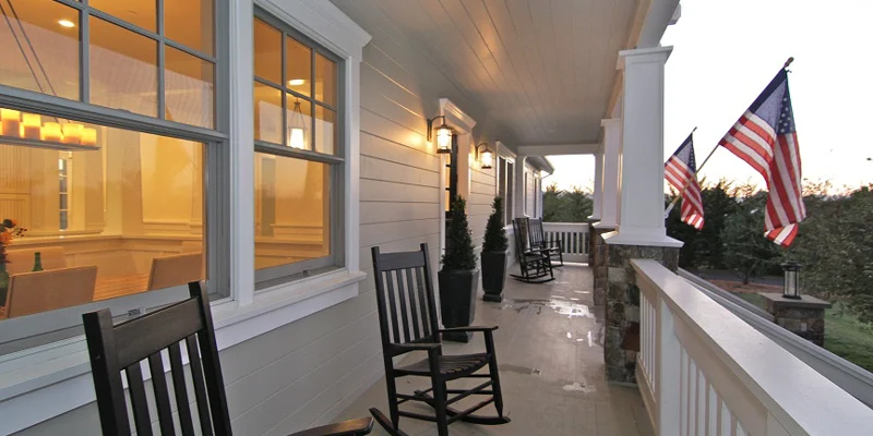 Porch with chairs and flags on columns.