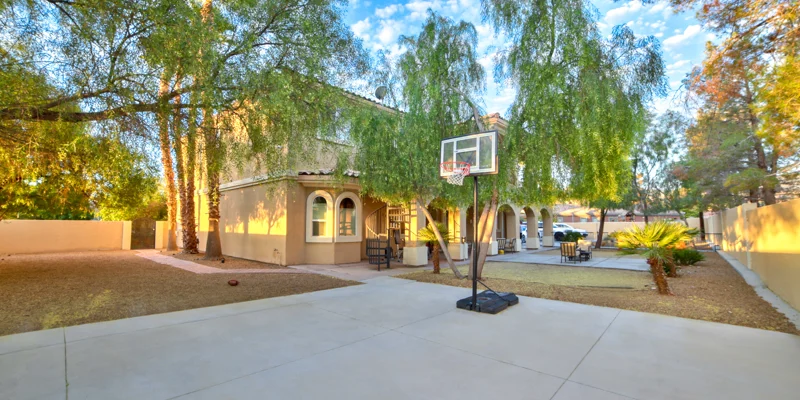 Backyard with a basketball court and a seating area.