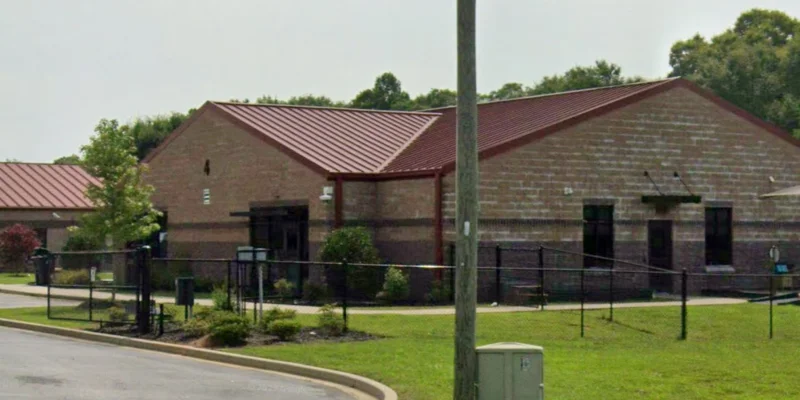 Exterior view of the rehab facility and Outdoor patio with seating and umbrellas.