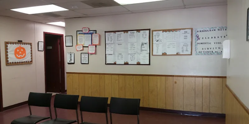 A waiting room with chairs and bulletin boards on the wall.