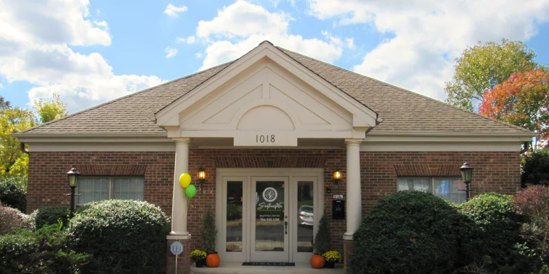 Brick building entrance with balloons and pumpkins