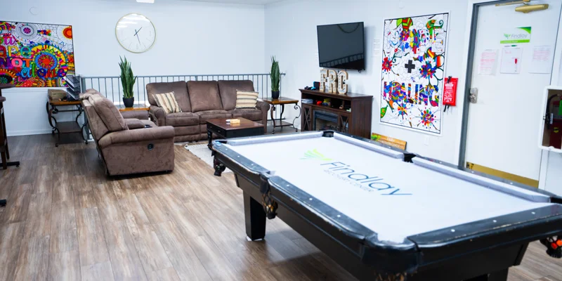 Cozy lounge with sofas, pool table, and colorful art