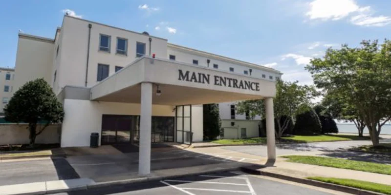 Exterior main entrace to facility with paved parking.