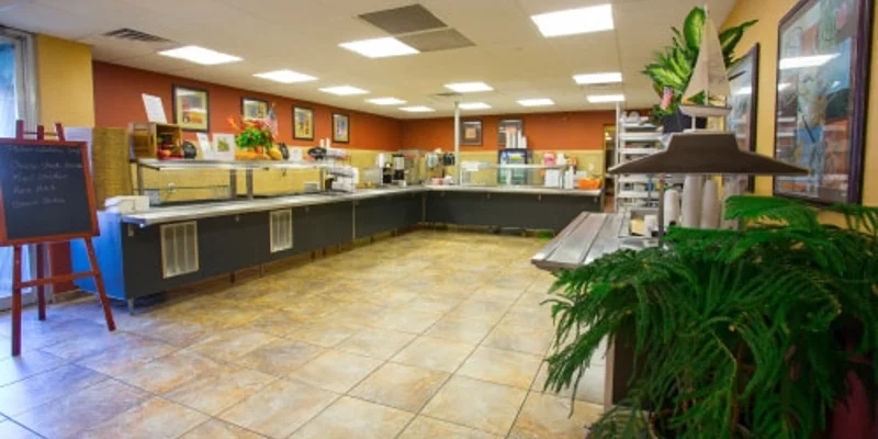 A cafeteria-style dining area with food stations and seating.