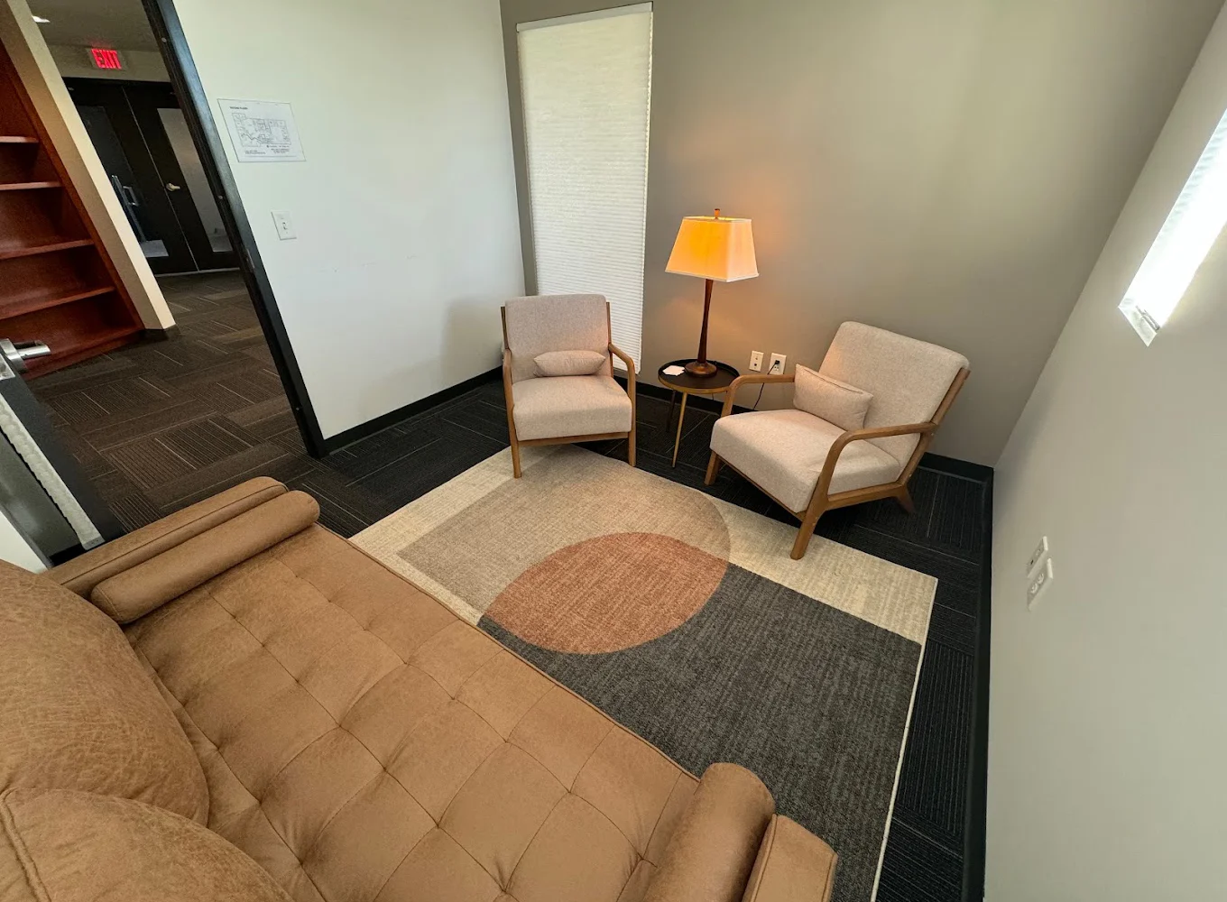 Small therapy room with beige chairs and a cozy atmosphere.