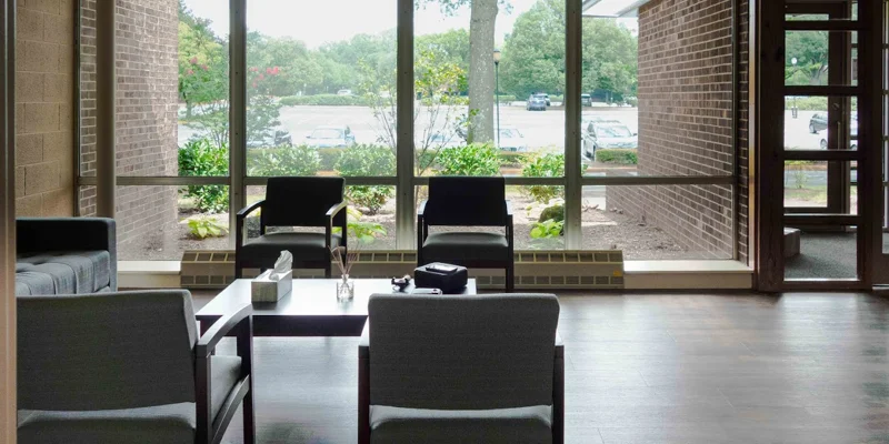 Waiting area with seats, large window, and decor.
