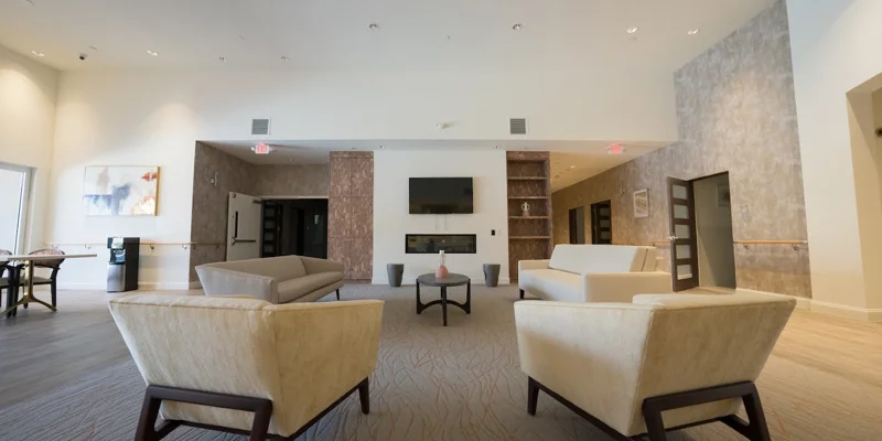 Large common area with neutral-toned furniture and a fireplace.