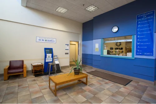 A lobby with a bench next to a reception window.