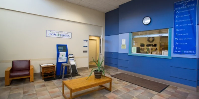 A lobby with a bench next to a reception window.