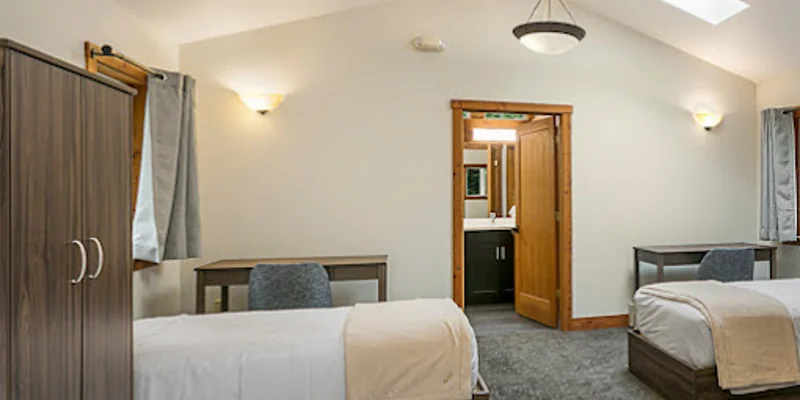 Shared bedroom with twin beds and a desk.