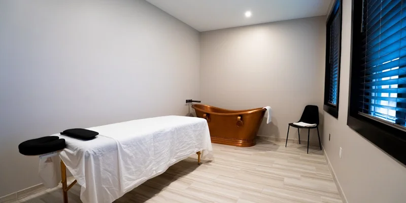 Private treatment room with massage table and copper soaking tub.