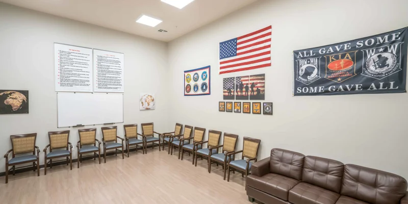 Group therapy room with chairs in a circle and a whiteboard.
