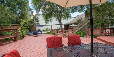 Outdoor deck with chairs and an umbrella.