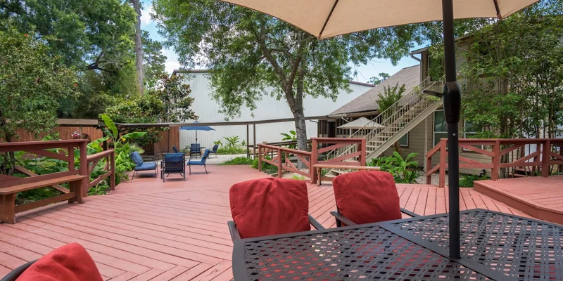Outdoor deck with chairs and an umbrella.