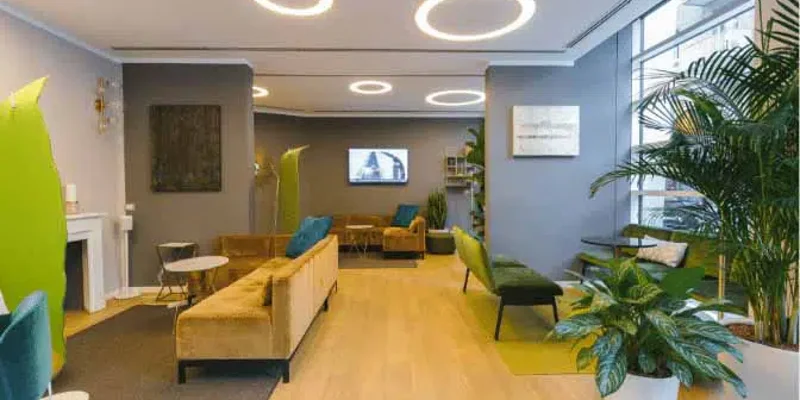 Spacious waiting area with tables, chairs, and large windows.