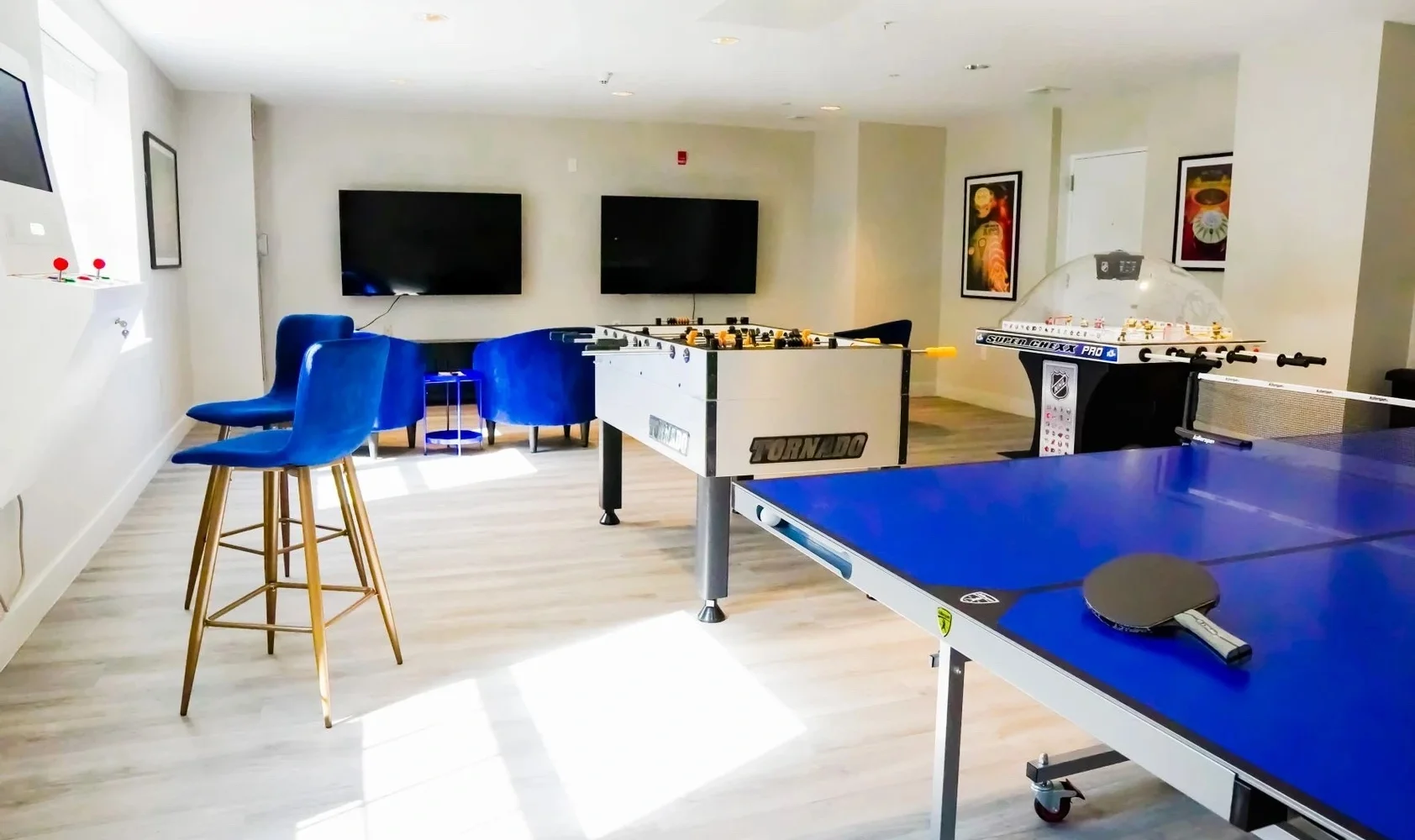 Game room with foosball, ping-pong, and seating.