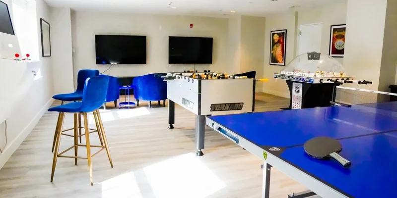 Game room with foosball, ping-pong, and seating.
