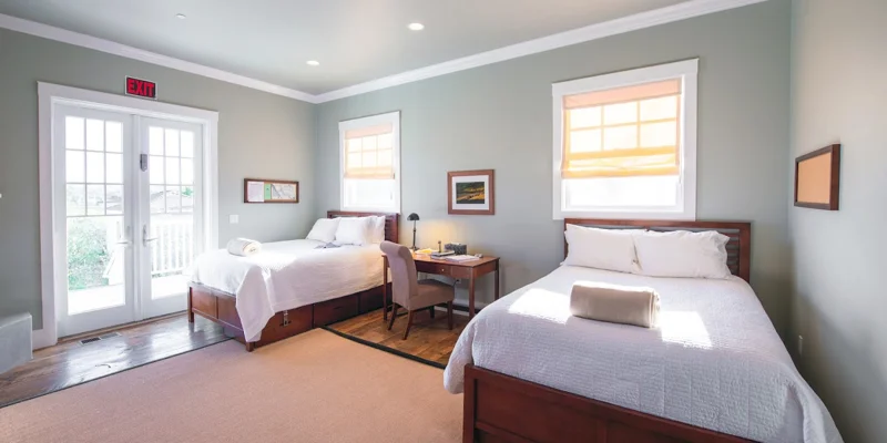 Shared bedroom with two beds and a small desk.