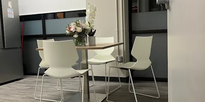 A small dining area with a table and white chairs.