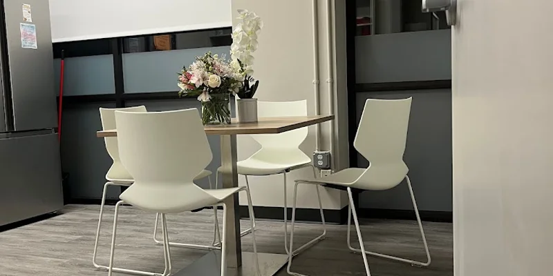 A small dining area with a table and white chairs.