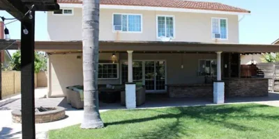 Entrance with a patio, seating, and a lawn.