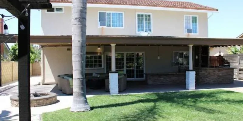 Entrance with a patio, seating, and a lawn.