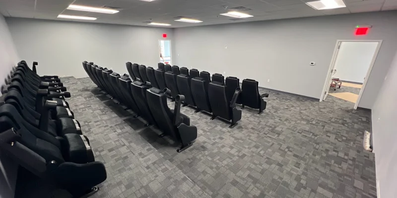 Theater-style room with seats in rows.