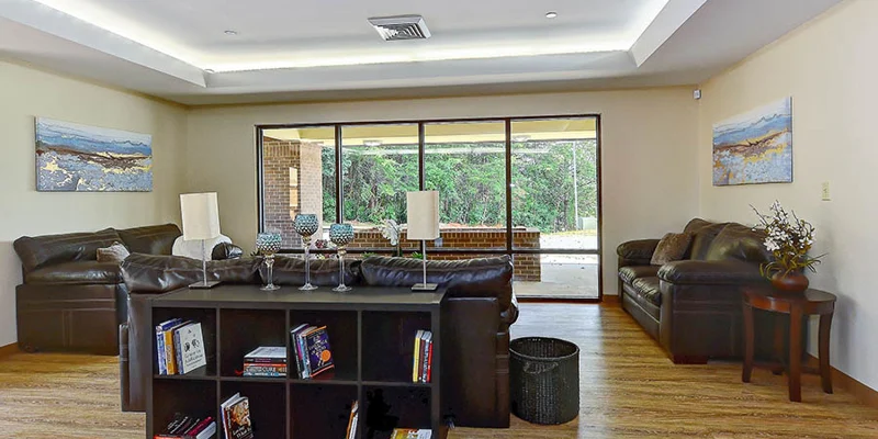 Open lounge area with leather sofas and large sliding doors.
