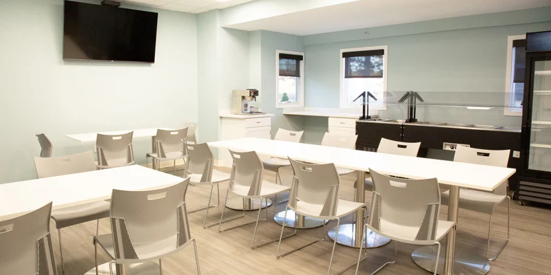 Dining area with seating, a TV, and a buffet station.