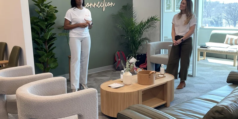 Two staff members standing in a welcoming space.