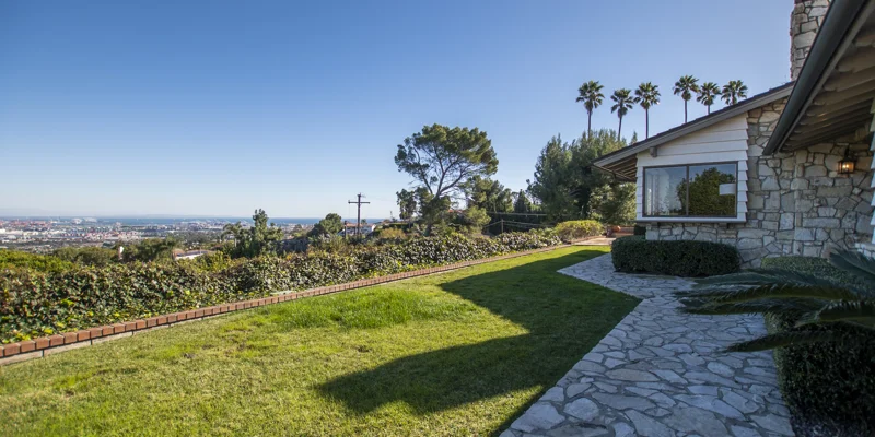 Outdoor view of a lush green lawn overlooking a cityscape