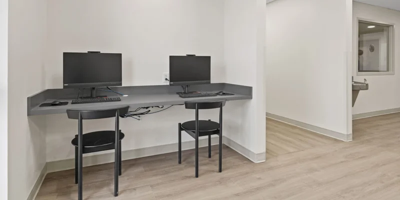 A small workstation with two computers for residents.