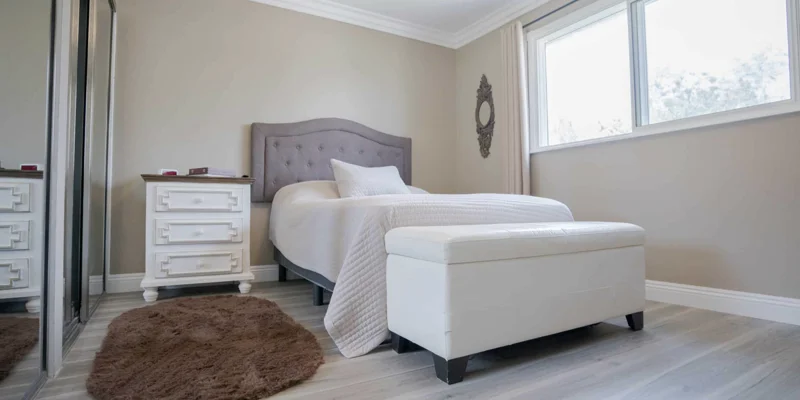 Private bedroom with a single bed, dresser, and mirrors.