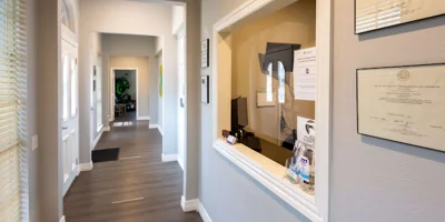 Reception hallway with a service window and framed certificates.