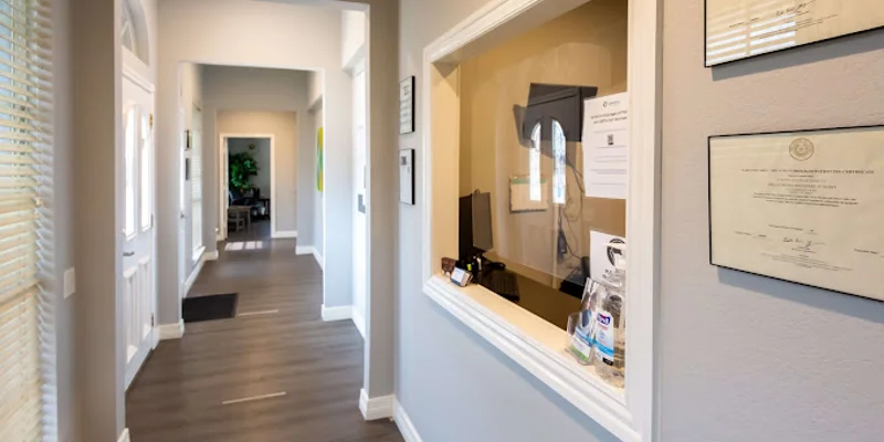 Reception hallway with a service window and framed certificates.