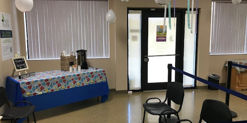 Waiting area with a refreshment table and chairs.