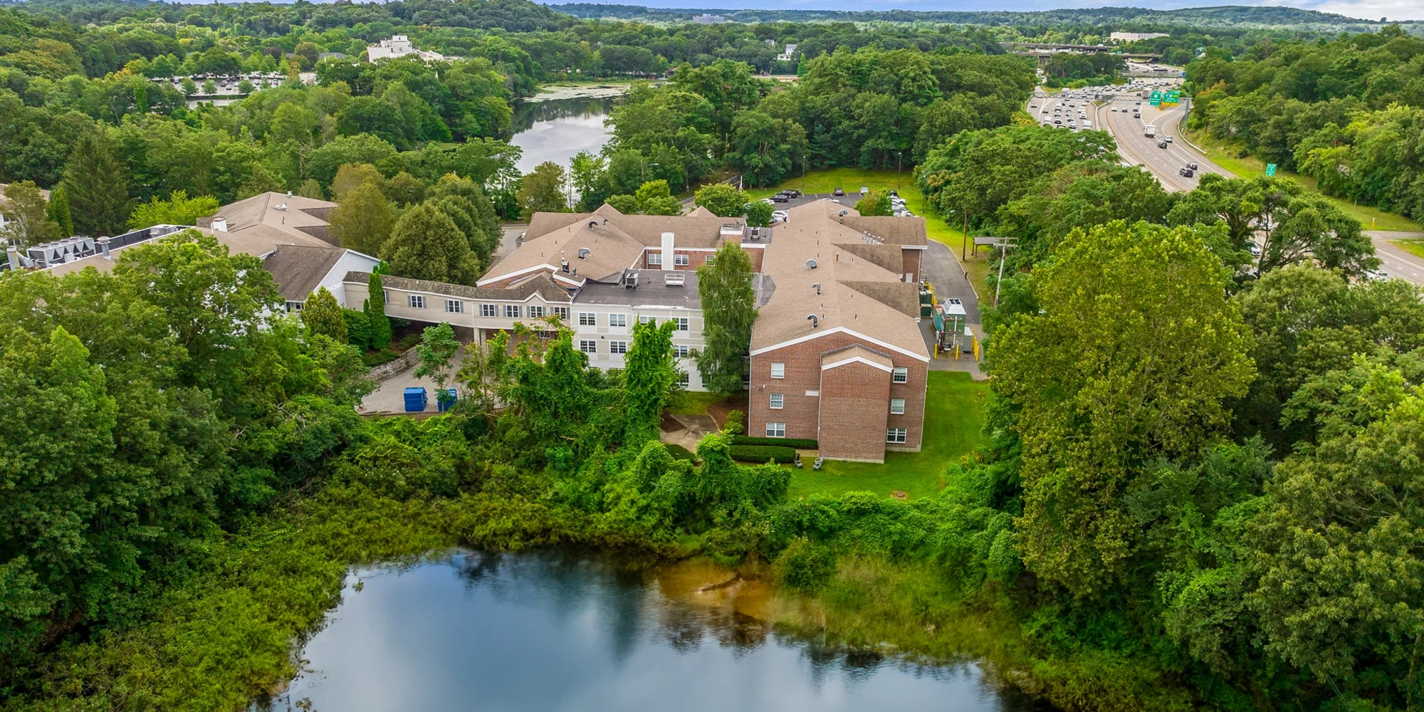 Aerial view of facility showing pond and greenery.
