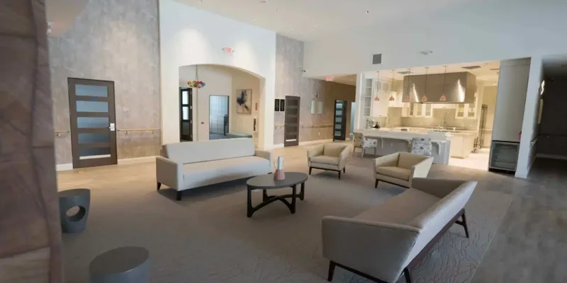 Bright common space with chairs, tables, and a welcoming ambiance.