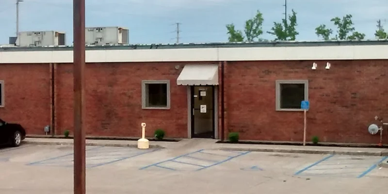 Single-story brick building with a white awning and accessible parking spaces.