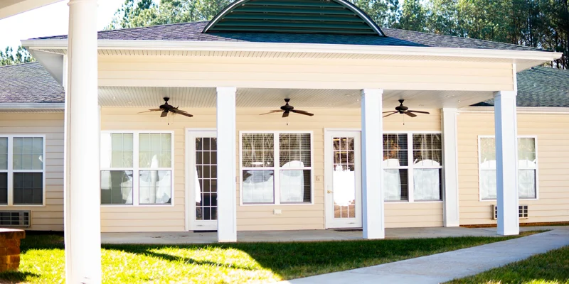 Outdoor patio with white columns and ceiling fans.
