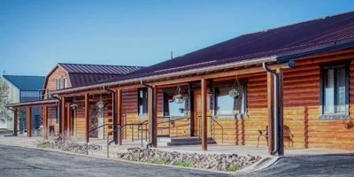 og cabin-style facility with a covered porch and hanging plants.