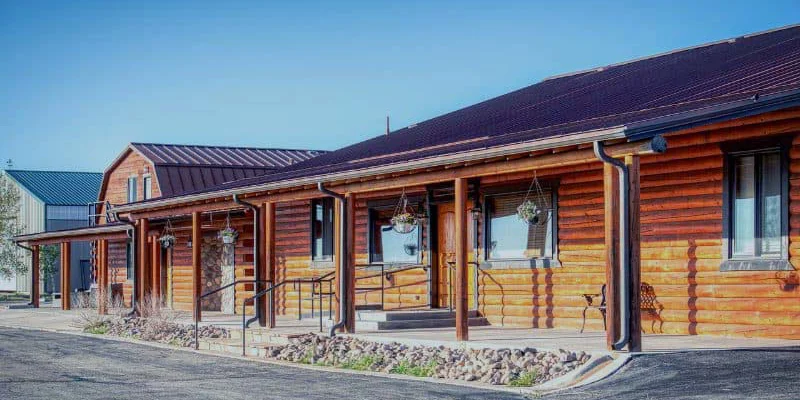 og cabin-style facility with a covered porch and hanging plants.