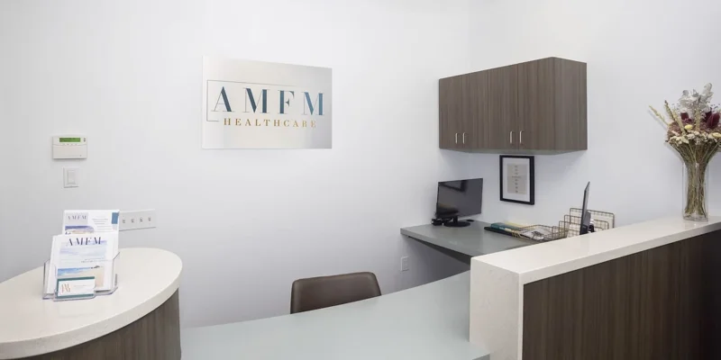 A reception desk with an "AMFM Healthcare" sign on the wall