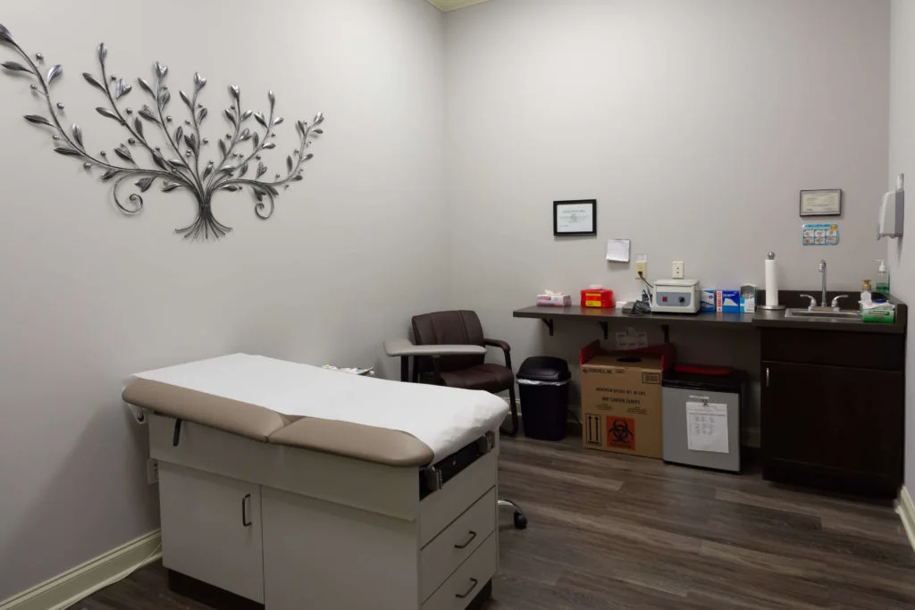 Medical exam room with bed and supplies.