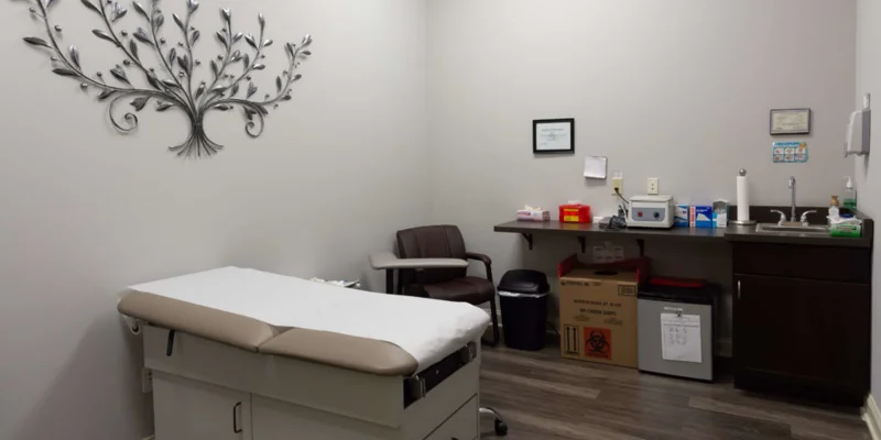 Medical exam room with bed and supplies.