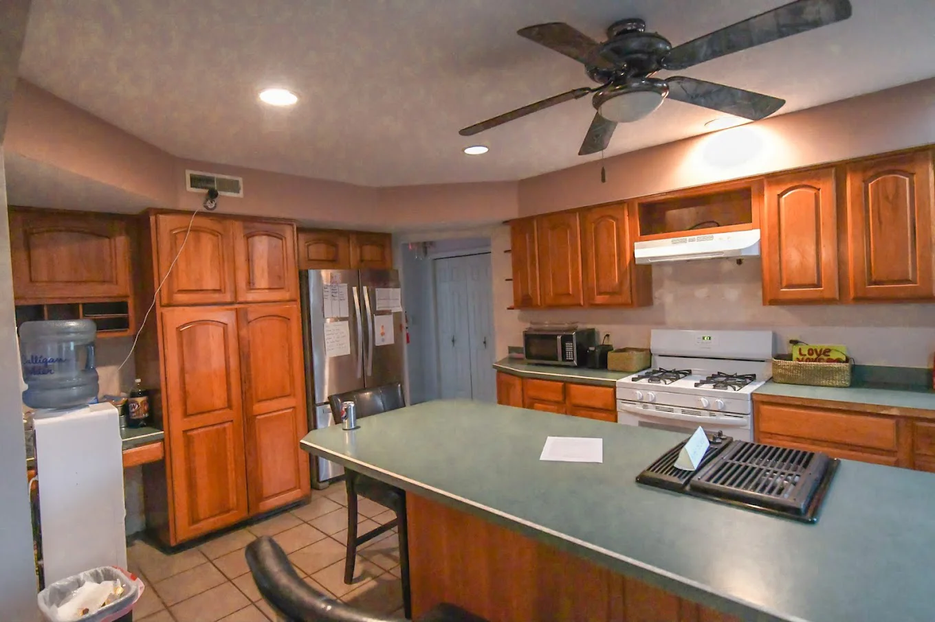 Kitchen with wooden cabinets, a large island, and modern appliances.