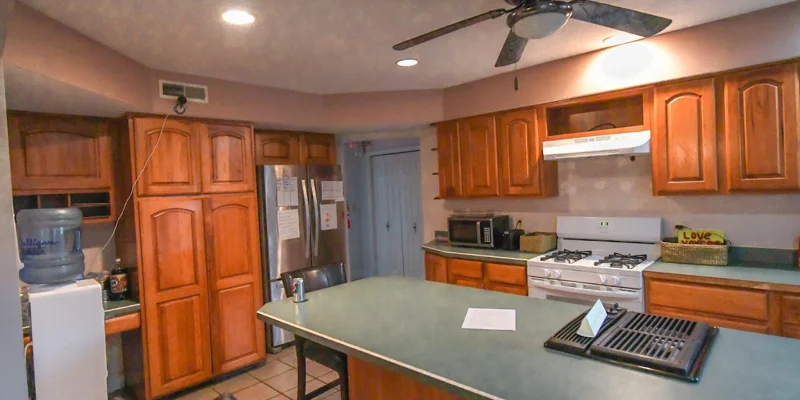 Kitchen with wooden cabinets, a large island, and modern appliances.